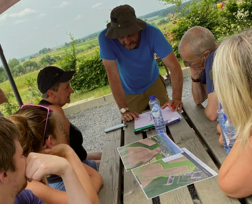 Un animateur qui explique le programme d'activités à des visiteurs